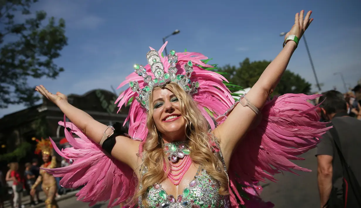 Seorang wanita mengenakan kostum berpose untuk difoto saat mengikuti Karnaval Notting Hill di London (28/8). Karnaval ini di gelar untuk merayakan budaya Karibia dan India Barat serta kesetaraan rasial di London. (AP Photo / Tim Irlandia)