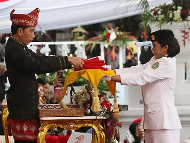 Presiden Joko Widodo menerima Bendera Merah Putih oleh anggota Paskibraka, Ruth Celine Eglesya Purba pada Upacara Penurunan Bendera HUT ke-72 Kemerdekaan RI di Halaman Istana Merdeka, Jakarta, Kamis (17/8). (Liputan6.com/Pool)