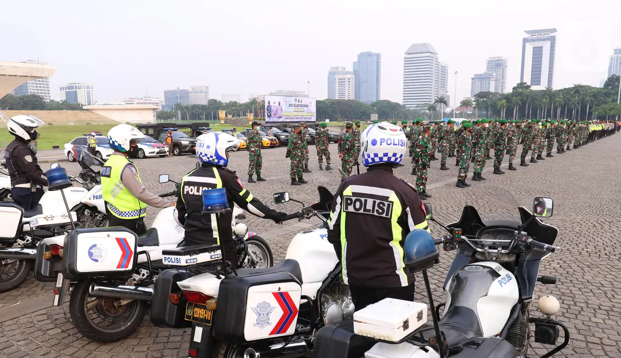 Personil gabungan melakukan apel pasukan pengamanan di Monas, Jakarta, Senin (19/7/2021). Pengamanan tersebut dilakukan untuk menjaga Hari Raya Idul Adha 1442 Hijriah dimasa pandemi Covid-19 saat PPKM Darurat. (Liputan6.com/Angga Yuniar)