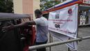 Seorang pria berusaha mengatur lalu lintas di sebelah spanduk yang mengatakan hanya kendaraan dengan kode QR yang akan diberi bahan bakar di sebuah pompa bensin di Kolombo, Sri Lanka, Senin, 1 Agustus 2022. Sri Lanka memperkenalkan distribusi bahan bakar menggunakan kode QR pada hari Senin sebagai bagian dari penerapan kuota mingguan untuk pengendara. (AP Photo/Eranga Jayawardena)