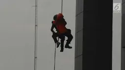 Petugas BNPB menyelamatkan korban dalam simulasi penaggulangan bencana di Gedung BNPB, Jakarta, Selasa (24/4). Simulasi ini melatih kesiapan menjelang peringatan apel Hari Kesiapsiagaan Bencana (HKB) pada Kamis, 26 April 2018. (Merdeka.com/Imam Buhori)
