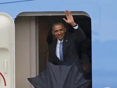 Presiden AS, Barack Obama melambaikan tangan saat turun dari pesawat Air Force One setibanya di Bandara Internasional Havana, Kuba, Minggu (20/3). Kunjungan Obama ini yang pertama dilakukan seorang presiden AS sejak 88 tahun lalu. (REUTERS/stringer)