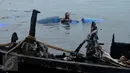 Petugas Basarnas dan Pol air memasang drum kosong ke sekeliling bangkai kapal Zahro Express di Pelabuhan Muara Angke, Jakarta, Rabu (4/1). Bangkai kapal Zahro Express mulai diangkat untuk mempermudah penyelidikan KNKT. (Liputan6.com/Gempur M Surya)