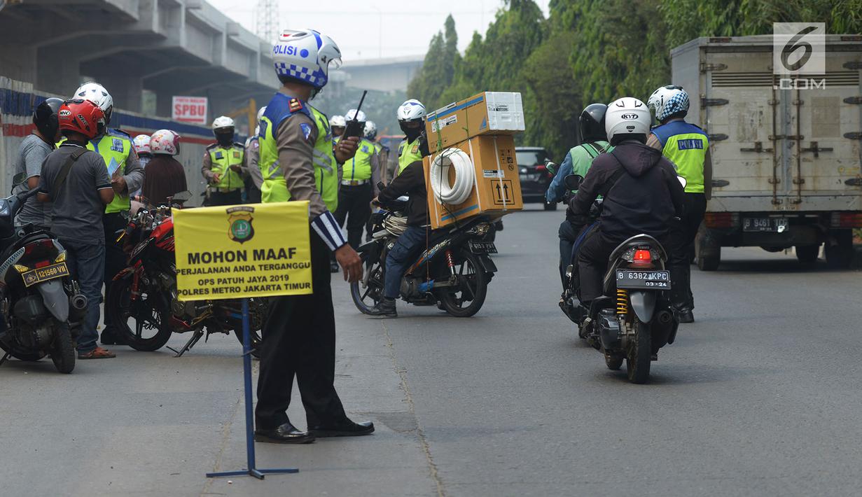 Polisi lalu lintas memberhentikan pengendara sepeda motor saat menggelar razia Operasi Patuh Jaya 2019 di kawasan Kebon Nanas, Jakarta, Kamis (29/8/2019). Diketahui, Operasi Patuh Jaya 2019 di wilayah hukum Polda Metro Jaya mulai digelar hari ini hingga 11 September 2019. (merdeka.com/Imam Buhori)