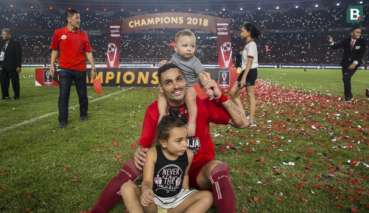 Bek Persija Jakarta, Jaimerson, bergembira bersama kedua anaknya merayakan gelar juara Piala Presiden di SUGBK, Jakarta, Sabtu (17/2/2018). Persija menang 2-0 atas Bali United. (Bola.com/Vitalis Yogi Trisna)