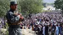 Polisi bersenjata bersiaga ketika umat muslim melaksanakan salat Idul Fitri di Provinsi Khost, Afghanistan, Selasa (4/6/2019). Selain Afghanistan, sejumlah negara juga merayakan Hari Raya Idul Fitri hari ini. (FARID ZAHIR/AFP)