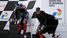 Pembalap Aprilia, Maverick Vinales (kanan) menggunakan kostum Batman saat berselebrasi di atas podium MotoGP Indonesia 2023 yang berlangsung di Sirkuit Mandalika, Lombok, NTB, Minggu (15/10/2023). Vinales berhasil merebut posisi kedua setelah finis di belakang Francesco Bagnaia. (AFP/Sonny Tumbaleka)