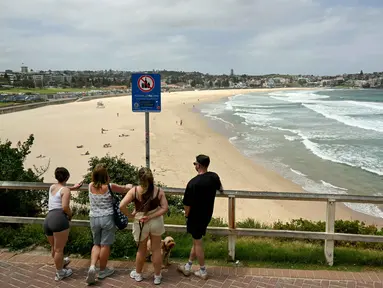 Orang-orang terlihat di Pantai Bondi, Sydney, Australia pada Senin 15 Desember 2025, sehari setelah penembakan. Suasana sekitar Pantai Bondi, Sydney, Australia mulai kembali kondusif. (Saeed KHAN/AFP)
