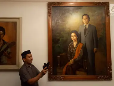 Pelayat memotret koleksi lukisan di rumah duka Presiden ke-3 RI BJ Habibie, Patra Kuningan, Jakarta, Rabu (11/9/2019). BJ Habibie meninggal pada Rabu, 11 September 2019 pukul 18.05 WIB. (Liputan6.com/Angga Yuniar)