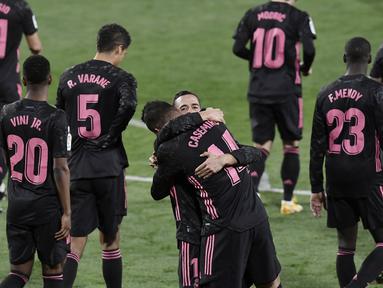 Pemain Real Madrid, Casemiro dan Lucas Vazquez, merayakan gol ke gawang Real Valladolid pada laga Liga Spanyol di Stadion Jose Zorrila, Minggu (21/2/2021). Real Madrid menang dengan skor 1-0. (AP/Alvaro Barrientos)