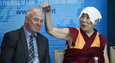 Dalai Lama menunjuk ke arah Dewan Komisaris Eropa untuk Hak Asasi Manusia, Nils Muiznieks saat ia pidato di Dewan Eropa di Strasbourg, Perancis, Kamis (15/9). Ini adalah kunjungan Eropa pertama Dalai Lama setelah lima tahun. (AFP PHOTO/Frederick Florin)