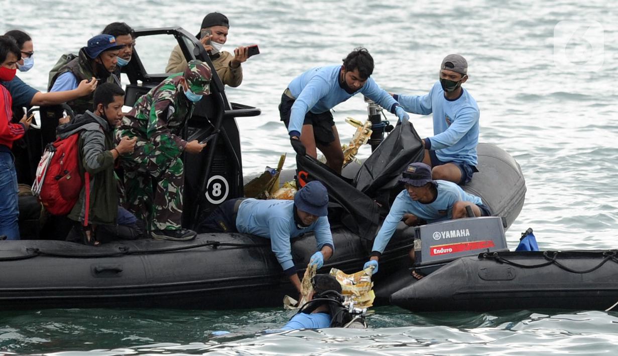Tim SAR mengevakuasi potongan pesawat Sriwijaya Air SJ 182 di perairan Kepulauan Seribu, Jakartra, Minggu (10/1/2021). Sriwijaya Air SJ 182 hilang kontak dalam penerbangan dari Jakarta menuju Pontianak. (merdeka.com/Arie Basuki)