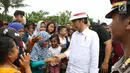 Presiden Joko Widodo atau Jokowi menyapa warga usai meninjau Bandara Soetta, Tangerang, Banten, Kamis (21/6). Dalam kegiatan ini, Jokowi juga membagikan buku dan kain batik kepada warga sekitar. (Liputan6.com/Angga Yuniar)