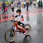 Seorang anak mengendarai sepeda saat CFD di kawasan Bundaran HI, Jakarta, Minggu (3/7/2022). Meski sempat diguyur hujan tidak menyurutkan  masyarak untuk berolahraga di akhir pekan. (Liputan6.com/Angga Yuniar)