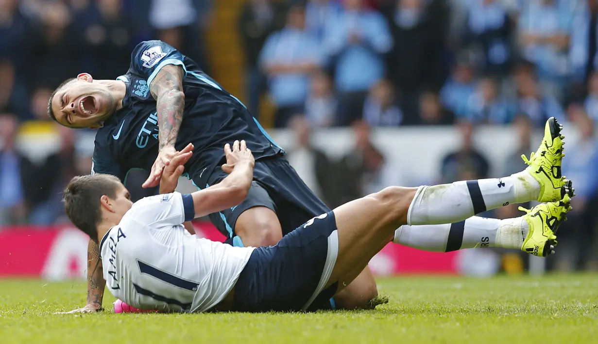 Bek sayap Manchester City, Aleksandar Kolarov terjatuh saat berebut bola dengan gelandang Tottenham, Erik Lamela pada laga Liga Inggris di Stadion White Hart Lane, London, Sabtu (26/9/2015). (Reuters/Eddie Keogh)
