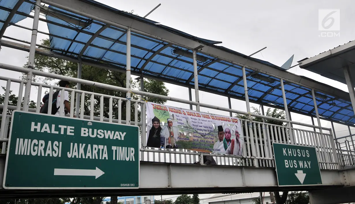 Pejalan kaki melintasi JPO di depan kantor Imigrasi Jakarta Timur, Kamis (17/1). JPO yang tidak terawat ini mengurangi keindahan serta mengganggu kenyamanan pejalan kaki yang melintas, terlebih saat hujan turun. (Merdeka.com/Iqbal S. Nugroho)