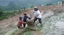 Warga membawa seekor kambing usai diselamatkan dari timbunan longsor di Dusun Cimapag, Desa Sirnaresmi, Kecamatan Cisolok, Sukabumi, Selasa (1/1). Longsor menerjang Dusun Cimapag pada 31 Desember 2018. (Merdeka.com/Arie Basuki)