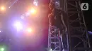 Penyanyi Nassar memanjat tiang panggung saat tampil memeriahkan acara Pestapora di Gambir Expo, Kemayoran, Jakarta, Minggu (25/9/2022). Nassar tampil menghibur dengan membawakan lagu seperti 'Kereta Malam', 'Seperti Mati Lampu', dan Sekuntum 'Mawar Merah'. (Liputan6.com/Herman Zakharia)
