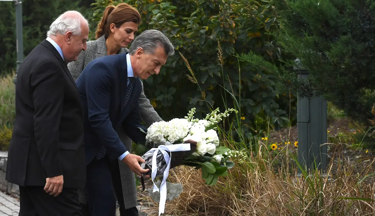 Presiden Argentina, Mauricio Macri didampingi Ibu Negara, Juliana Awada meletakkan karangan bunga di lokasi serangan truk pikap di New York, Selasa (7/11). Lima dari delapan korban meninggal adalah warga Argentina. (AFP PHOTO / TIMOTHY A. CLARY)