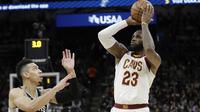 Aksi pemain Cleveland Cavaliers, LeBron James (23) melakukan tembakan melewati pemain Spurs, Danny Green (kiri) pada lanjutan NBA di basketball game di AT&T Center, San Antonio, (23/1/2018). Spurs menang 114—102. (AP/Eric Gay)