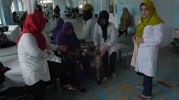 Seorang dokter Afghanistan (kedua kanan) memeriksa kondisi pasien yang diamputasi di pusat ortopedik Komite Internasional Palang Merah (ICRC), rumah sakit bagi korban perang dan yang diamputasi, di Kabul, Minggu (3/4).  (SHAH Marai/AFP)