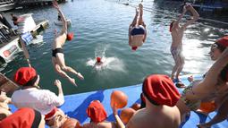 Sejumlah peserta beraksi dalam perlombaan renang bertajuk Copa Nadal (Piala Natal) edisi ke-115 yang berlangsung di Port Vell, Barcelona, Spanyol, Rabu (25/12/2024). Ajang tersebut diikuti oleh 450 peserta dengan jarak renang sejauh 200 meter. (AFP/Josep Lago)