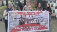 Personel Polresta Pekanbaru menyambangi masyarakat mengampanyekan Pilkada damai. (Liputan6.com/M Syukur)