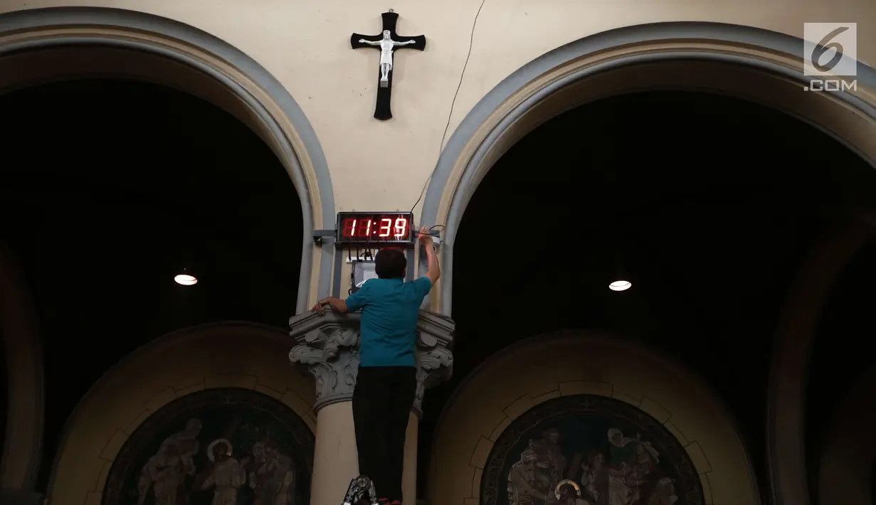 Seorang pria memasang jam digital di dalam Gereja Katedral, Jakarta, Sabtu (23/12). Dari pembenahan peralatan pendukung hingga penataan dekorasi dilakukan untuk menyemarakkan perayaan natal pada 25 Desember. (Liputan6.com/Angga Yuniar)