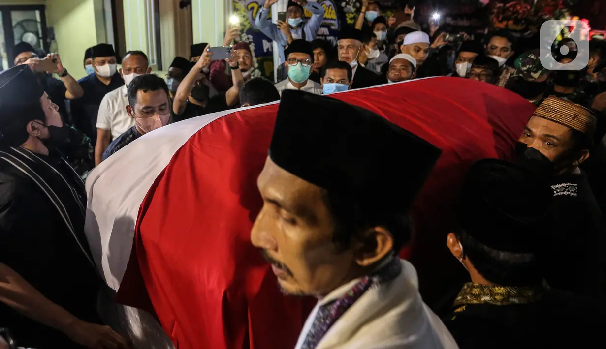 Saudara serta Kerabat mengangkat dan mendorong Peti Jenazah Ketua Dewan Pers Azyumardi Azra di rumah duka di Perumahan Puri Laras II, Cirendeu, Tangerang Selatan, Senin (19/9/2022) tengah malam. Azyumardi Azra meninggal dunia pada Minggu (18/9/2022) di rumah sakit Kedah, Selangor, Malaysia pukul 12.30 waktu setempat, dan rencana akan dimakamkan Selasa (20/9/2022) di Taman Makam Pahlawan (TMP) Kalibata. (Liputan6.com/Johan Tallo)