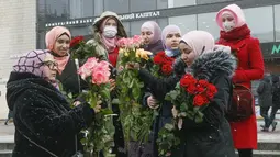 Aktivis berhijab memegang bunga saat memperingati Hari Hijab Sedunia di Kyiv, Ukraina, Senin (1/2/2021). Hari Hijab Sedunia diperingati setiap tanggal 1 Februari untuk menunjukkan solidaritas dengan wanita Muslim yang mengalami diskriminasi untuk mengenakan hijab. (AP Photo/Efrem Lukatsky)