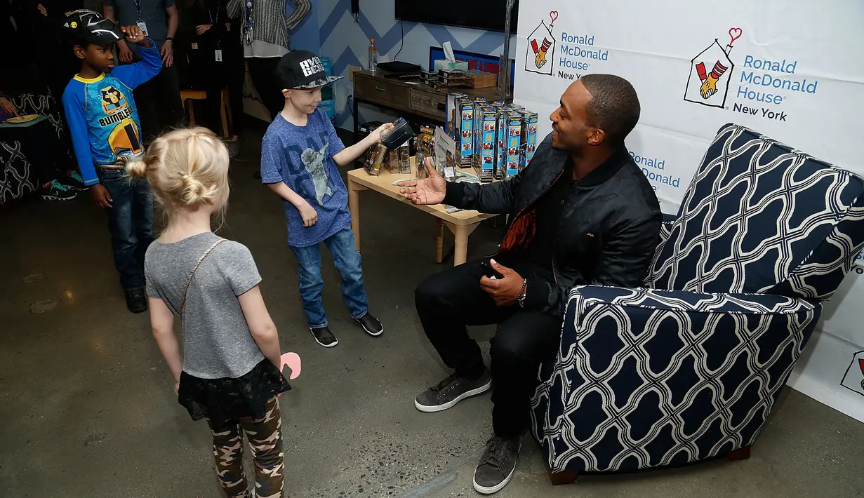 Senyum bintang Avengers Infinity War, Anthony Mackie menyapa anak-anak saat membagikan mainan di Ronald McDonald House, New York, AS, Kamis (19/4). Mainan yang dibagikan disumbangkan dari Hasbro. (LARS NIKI / GETTY IMAGES NORTH AMERICA / AFP)