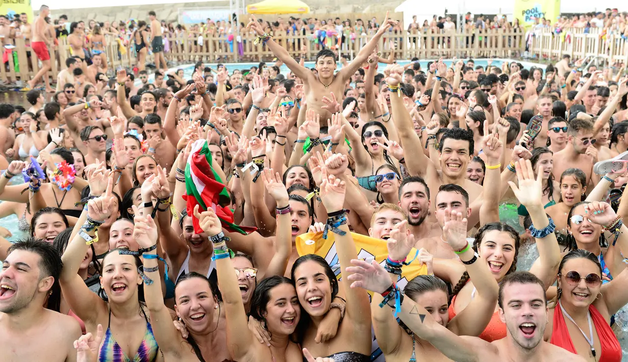 Ekspresi para pengunjung berjoget menikmati musik di dalam kolam Festival Arenal Sound di Pantai Burriana, Spanyol (2/8). Festival musik ini berlangsung sampai 7 Agustus 2017. (AFP Photo/Jose Jordan)