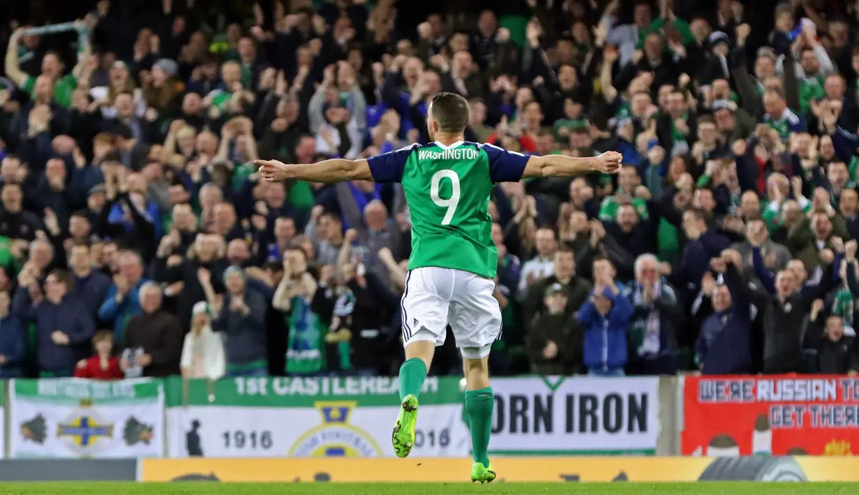 Striker Irlandia Utara, Conor Washington, merayakan gol yang dicetaknya ke gawang Norwegia pada laga kualifikasi Piala Dunia 2018 di Stadion Windsor Park, Irlandia, Minggu (26/3/2017). Irlandia Utara menang 2-0 atas Norwegia. (AFP/Paul Faith)