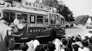 Sejumlah warga melihat sebuah bus dengan foto Pangeran Mahkota Jepang Akihito dan istrinya Michiko Shoda selama merayakan pernikahan mereka pada April 1959. (AFP Photo)