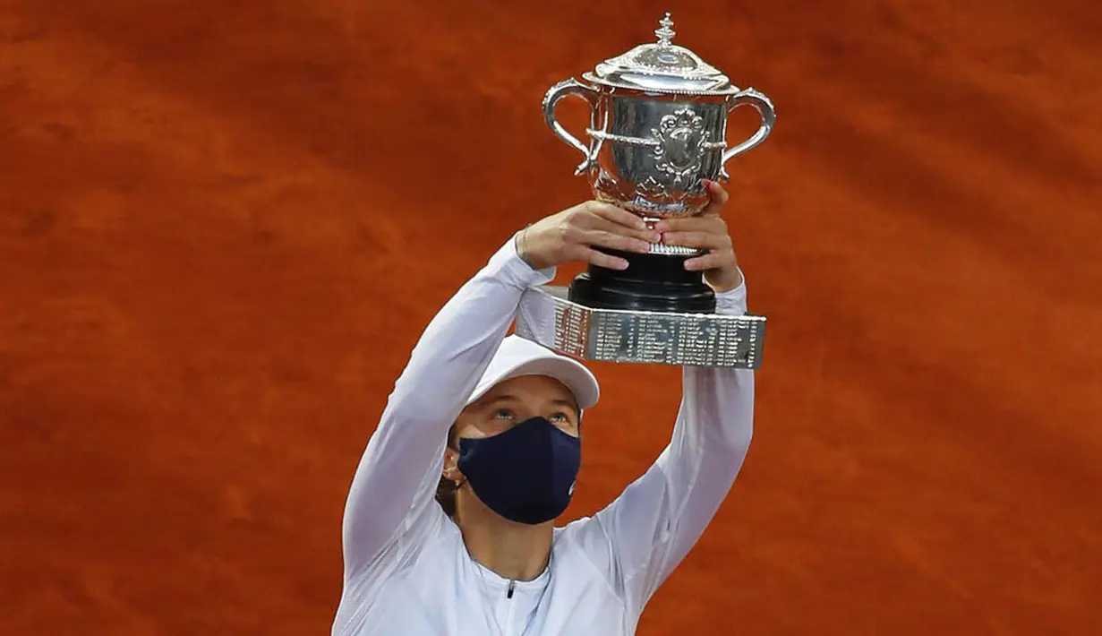 Petenis Polandia, Iga Swiatek, melakukan selebrasi mengangkat trofi usai menjuarai Grand Slam Prancis Terbuka di Paris, Sabtu, Sabtu (10/10/2020). Petenis berusia 19 tahun itu menaklukkan wakil Amerika Serikat, Sofia Kenin, dua set langsung 6-4 dan 6-1. (AP Photo/Alessandra Tarantino)