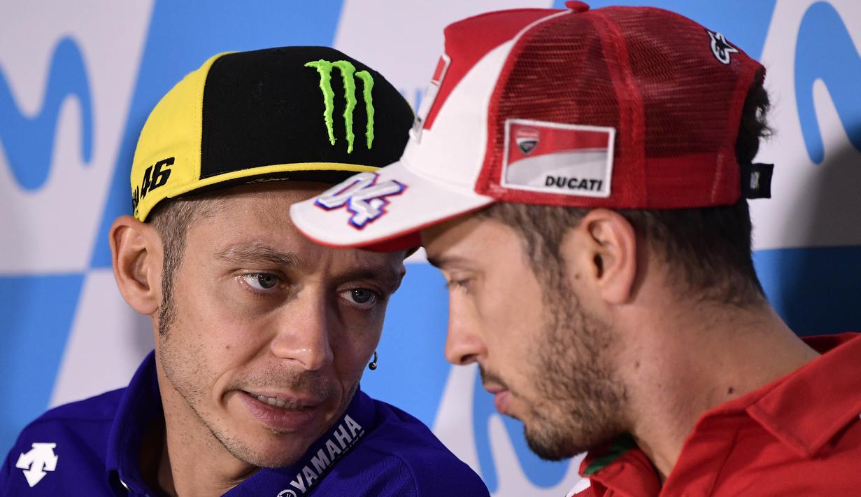 Pebalap Movistar Yamaha, Valentino Rossi, berbincang dengan Andrea Dovizioso saat jumpa pers jelang GP Aragon di Alcaniz, Aragon, Kamis (21/9/2017). Rossi dinyatakan lolos tes medis untuk mengikuti balapan MotoGP Aragon. (AFP/Javier Soriano)