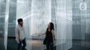 Pengunjung berpose saat mengunjungi pameran seni berbasis teknologi berwujud sorotan cahaya futuristik 'Wave of Tomorrow' di Jakarta, Sabtu (21/12/2019). Pameran seni Wave of Tomorrow menghadirkan tiga kelompok instalasi yaitu legacy, now, dan tomorrow.  (Liputan6.com/Faizal Fanani)