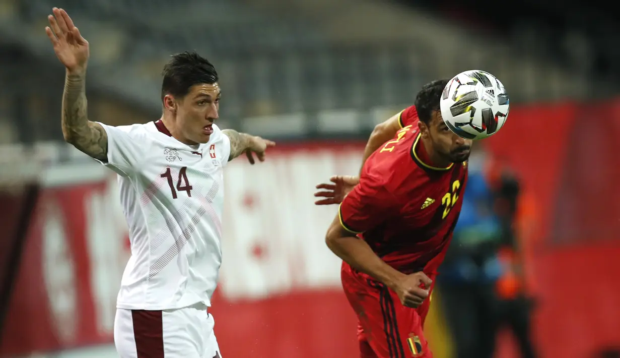 Gelandang Belgia, Nacer Chadli berebut bola dengan gelandang Swiss, Swiss Steven Zuber dalam pertandingan persahabatan di King Power Stadion At Den Dreef, Kamis (12/11/2020) dini hari WIB. Timnas Belgia meraih kemenangan tipis 2-1 atas Swiss. (AP Photo/Francisco Seco)