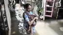 Warga menggendong anaknya saat melintasi banjir di permukiman warga di kawasan Kemang Timur XI, Jakarta Selatan, Minggu (21/2/2021). Ketinggian air mencapai sepinggang orang dewasa. (merdeka.com/Iqbal S. Nugroho)