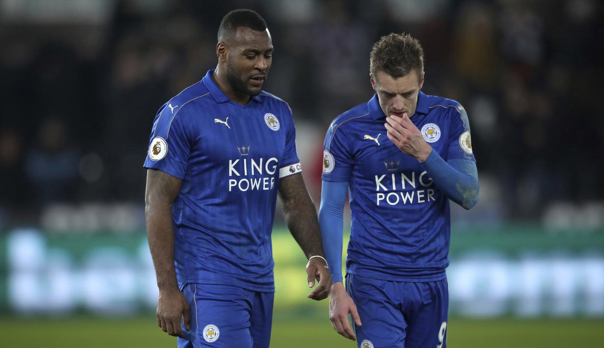 Dua punggawa Leicester City, Wes Morgan (kiri) dan Jamie Vardy meninggalkan lapangan usai kalah dari Swansea City  pada lanjutan Premier League di Liberty Stadium, Swansea, Wales,  (12/2/2017). Swansea menang 2-0. (Nick Potts/PA via AP)