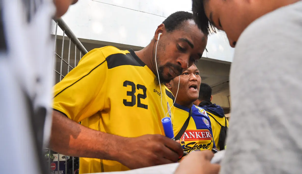 Lancine Kone memberikan tanda tangan kepada penggemar seusai latihan Arema Cronus di Stadion Manahan, Solo, Jumat (9/10/2015). (Bola.com/Kevin Setiawan)