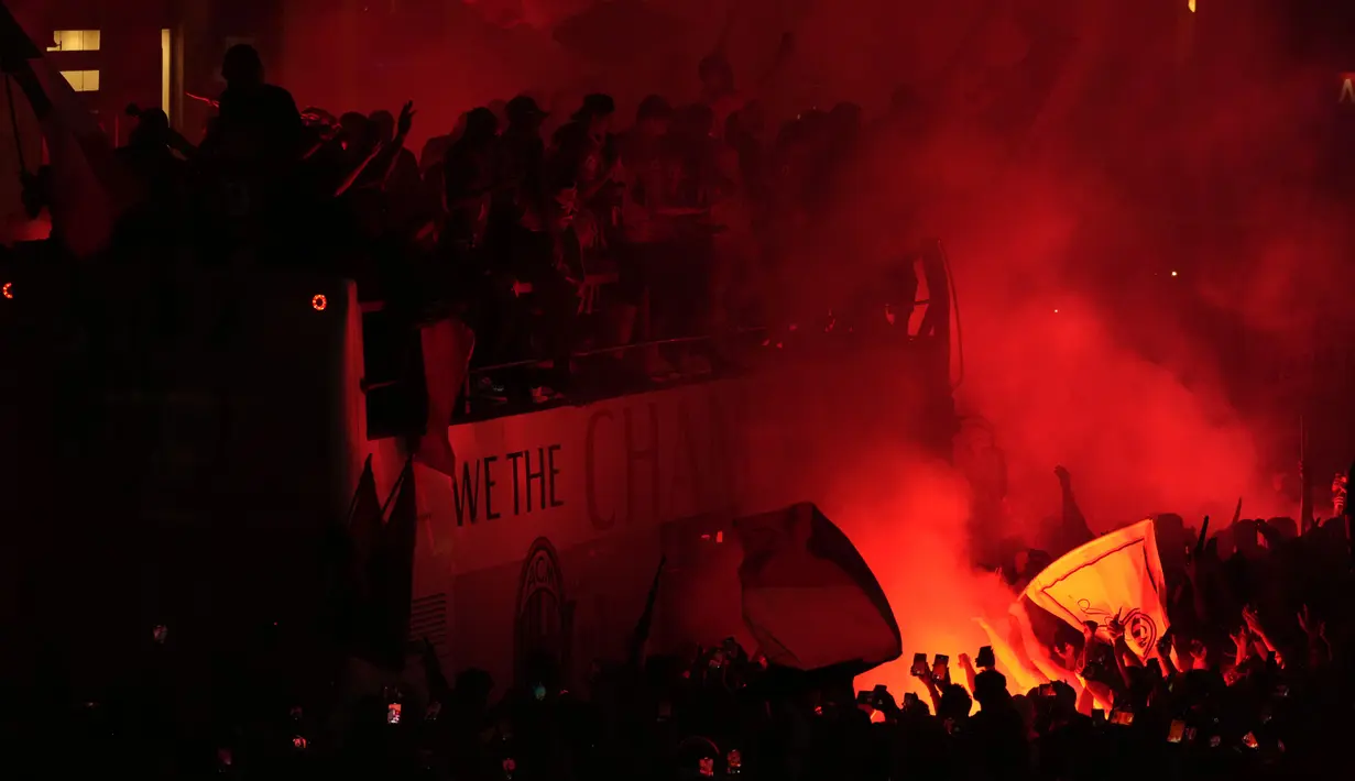 Ribuan penggemar bersorak saat bus yang membawa para pemain tim sepak bola AC Milan melakukan parade kemenangan Liga Italia di depan Katedral Gotik Milan, Milan, Italia, 23 Mei 2022. (AP Photo/Luca Bruno)