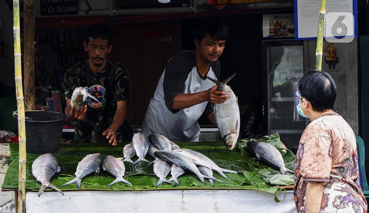 Pedagang ikan bandeng melayani pembeli di kawasan Rawa Belong, Jakarta Barat, Rabu (10/2/2021). Jelang Tahun Baru Imlek 2021, para pedagang ikan bandeng mulai bermunculan di Rawa Belong. (Liputan6.com/Johan Tallo)