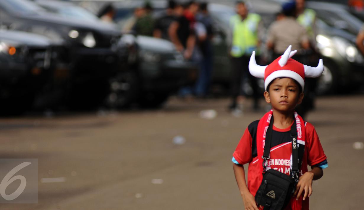 Seorang anak berpakaian ala suporter Semen Padang saat memasuki areal Stadion GBK Jakarta, Minggu (24/1/2016). Semen Padang akan melawan Mitra Kukar dalam laga final Piala Jenderal Sudirman. (Liputan6.com/Helmi Fithriansyah)