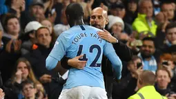 Pelatih Manchester City, Pep Guardiola, memeluk Yaya Toure usai laga melawan Brighton and Hove Albion di Stadion Etihad, Rabu (9/5/2018). Laga tersebut menjadi ajang perpisahan sang pemain bersama The Citizens. (AFP/Paul Ellis)