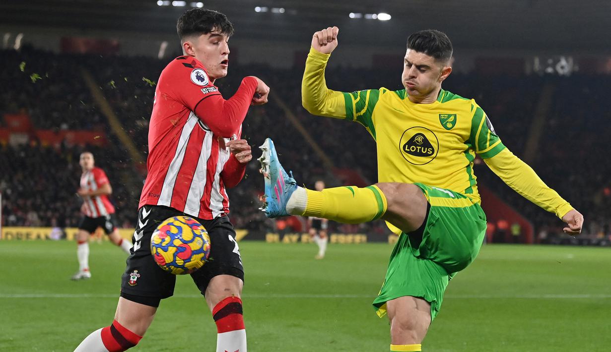 Bek Southampton, Tino Livramento (kiri) berebut bola dengan gelandang Norwich City, Milot Rashica pada laga Liga Inggris 2021/2022 di St Mary's Stadium, Southampton (25/2/2022). Didatangkan dari Chelsea pada awal musim 2021/2022, Toni Livramento langsung jadi andalan Southampton di posisi bek kanan. Sayang, cedera memaksanya absen sepanjang musim 2022/2023. Arsenal dan Chelsea siap menampungnya musim depan. (AFP/Glyn Kirk)