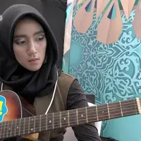 Salah satu peserta audisi Puteri Muslimah Indonesia 2017 membawa gitar. 