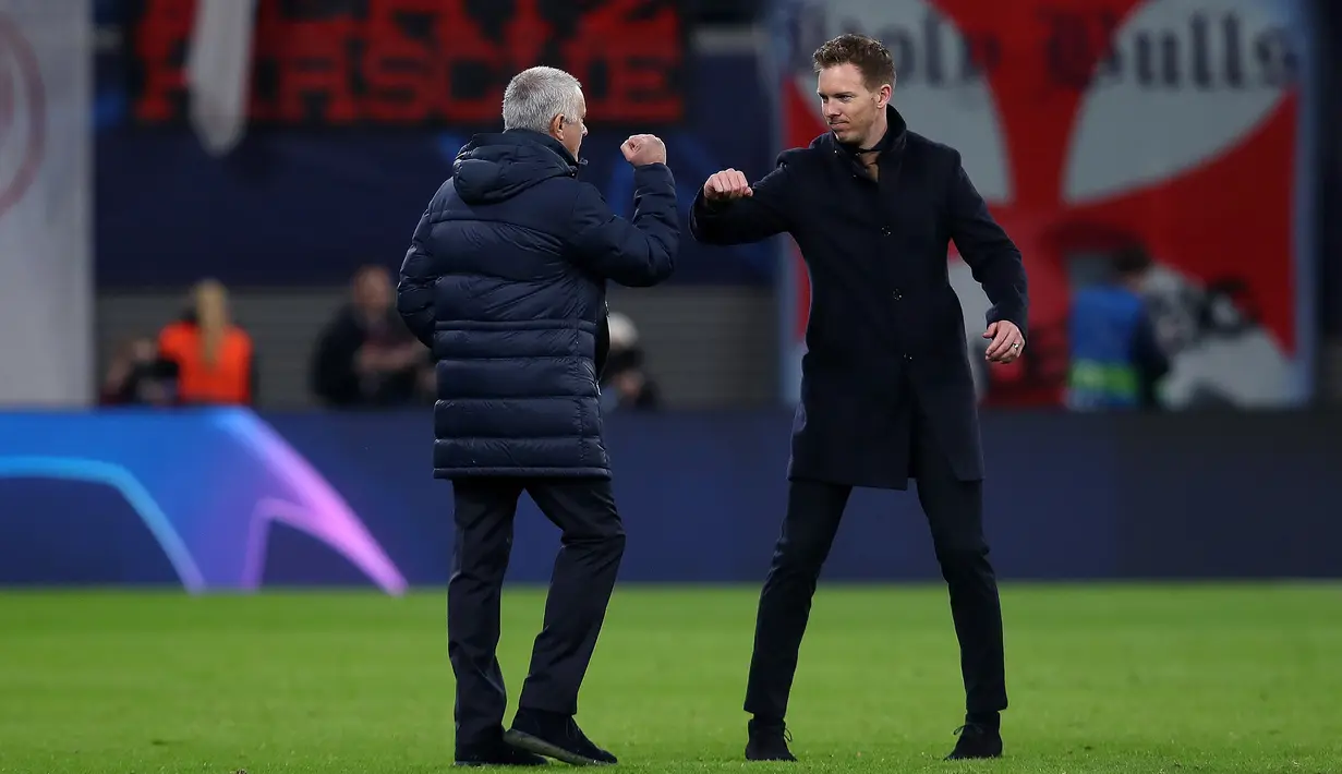 Pelatih Tottenham Hotspur, Jose Mourinho dan pelatih RB Leipzig Julian Nagelsmann melakukan "Elbow bump" diakibatkan mewabahnya virus corona usai pertandingan leg kedua babak 16 besar Liga Champions di Red Bull Arena, Jerman (10/3/2020). (AFP/Ronny Hartmann)