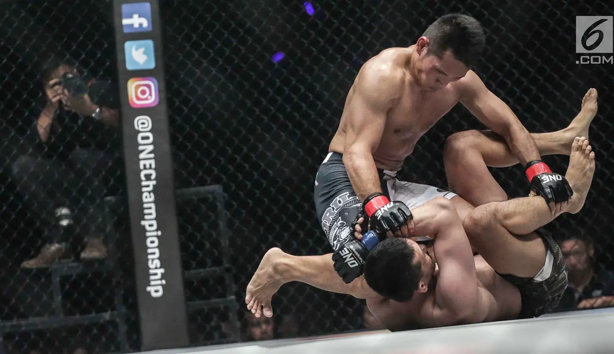 Dua petarung Indonesia Victorio Senduk (kiri) berusaha mengunci gerak Yohan Mulia Legowo (bawah) saat berlaga pada One Championship di Jakarta, Sabtu (20/1). Pada laga tersebut Victorio Senduk menang atas Yohan Mulia. (Liputan6.com/Faizal Fanani)