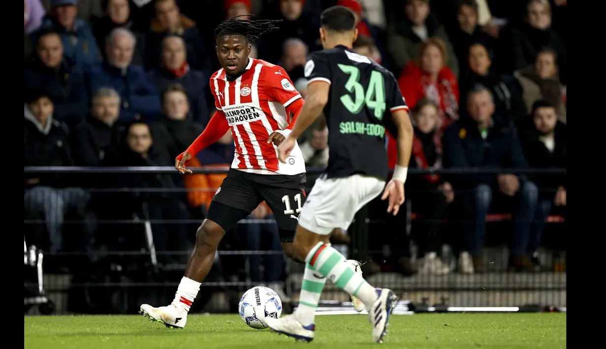 Pemain PSV, Johan Bakayoko (kiri) berusaha melewati penjagaan pemain FC Twente, Anass Salah-Eddine pada laga lanjutan Liga Belanda 2024/2025 di Phillips Stadium, Eindhoven, Belanda, Sabtu (07/12/2024). (AFP/ANP/Maurice Van Steen)